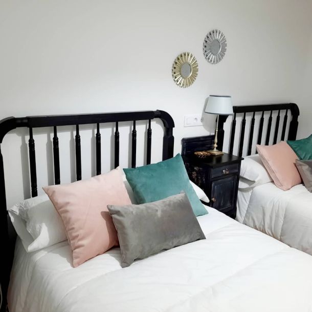 Imagen de habitación con doble cama decorada con almohadas de colores 