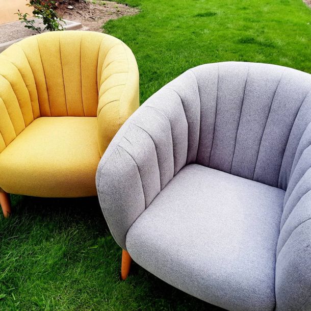 Imagen de dos sofás amarillo y gris en el exterior de una casa