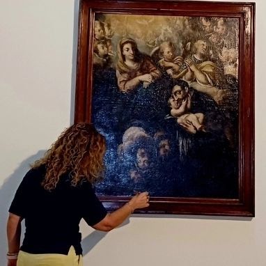 Foto de iglesia con trabajos realizados de restauración Sonia Marco  tocando el cuadro 